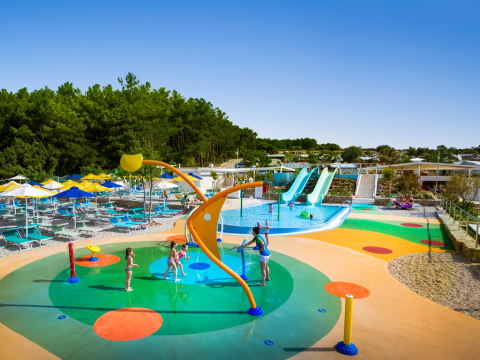 Børn leger på farverig vandlegeplads og rutsjebaner ved Valamar Camping Krk feriepark i Kroatien.