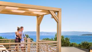 Coppia che si gode la vista mare dalla terrazza Bella Vista Home Garden sotto il pergolato in una giornata limpida.