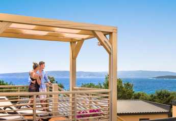 Par nyder udsigten over havet fra Bella Vista Home Garden terrassen under en pergola med klart vejr.