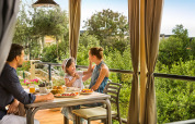Gezin geniet samen van ontbijt op het overdekte terras bij Bella Vista Home, Valamar Camping Krk, Kroatië.