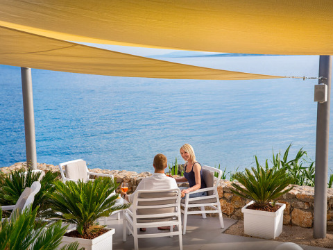 Pareja relajándose bajo toldos con vista al mar en Valamar Camping Krk, Primorje-Gorski Kotar, Croacia.