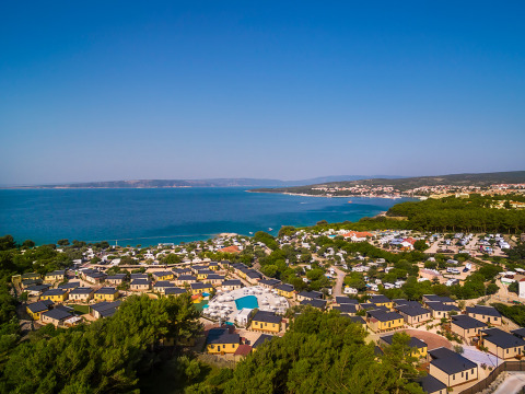 Luftfoto af Valamar Camping Krk i Primorje-Gorski Kotar, Kroatien med hytter, telte og udsigt til havet.