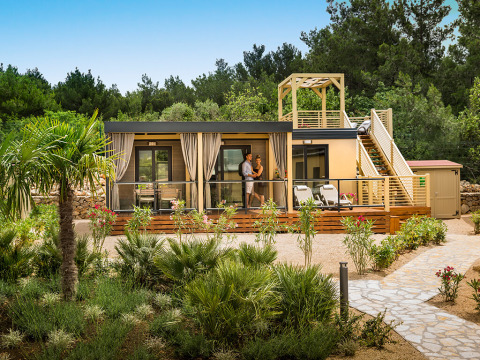 Terrasse Bella Vista Home Garden au Valamar Camping Krk en Croatie, entourée de verdure et d’arbres.