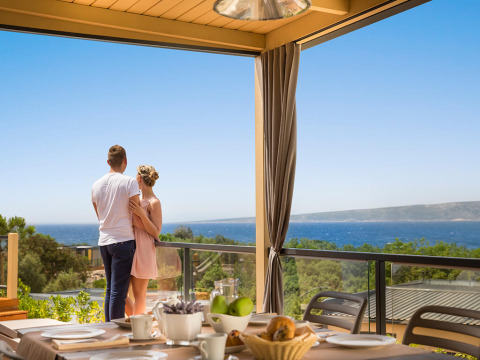 Un couple profite de la vue sur l'océan au Bella Vista Home Spectacular view lodge, table de petit-déjeuner dressée.