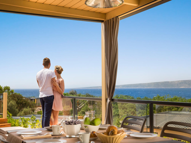 Et par nyder udsigten fra Bella Vista Home Spectacular view lodge med havudsigt og udendørs morgenbord.