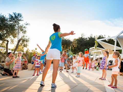 Kinder nehmen an Outdoor-Spielen mit einer Betreuerin im Valamar Camping Krk, Kroatien teil.