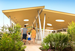 Una famiglia percorre un sentiero tra piante e strutture moderne al Valamar Camping Krk in Croazia.