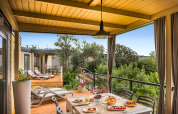 Overdekt terras van Bella Vista Home bij Valamar Camping Krk in Kroatië, met ontbijttafel en zicht op groen.