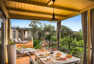 Overdekt terras van Bella Vista Home bij Valamar Camping Krk in Kroatië, met ontbijttafel en zicht op groen.