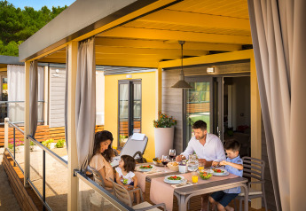 Familia disfrutando de una comida en terraza cubierta en el lodge Bella Vista Home, rodeados de naturaleza.