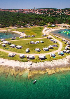 Luftfoto af Camping Arena Stupice i Istrien, Kroatien, med campingvogne nær det klare, blå hav.