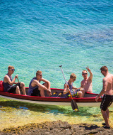 Fem mænd nyder en kano i det klare vand nær kysten i nærheden af Premantura, Istrien, Kroatien.