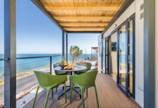 Terrazza vista mare con sedie verdi al Camping Arena Stupice, villaggio turistico in Istria, Croazia.