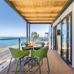 Udsigt fra terrasse med havudsigt og grønne stole på Camping Arena Stupice, en feriepark i Istrien, Kroatien.