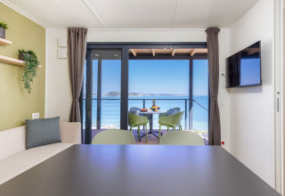 Casa vacanze moderna con vista mare, zona pranzo e terrazza al Camping Arena Stupice in Istria, Croazia.