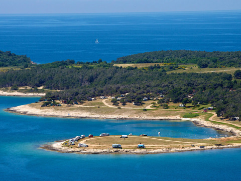 Luftfoto af Camping Arena Stupice med campingvogne ved kysten i Istrien, Kroatien, omgivet af blåt hav.