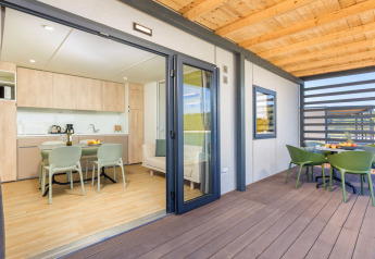 Modern Camping Home lodge at Camping Arena Stupice in Croatia, featuring a spacious terrace and dining area.