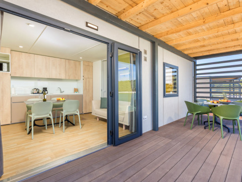 Modern Camping Home lodge at Camping Arena Stupice in Croatia, featuring a spacious terrace and dining area.