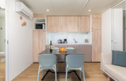 Cuisine moderne et coin repas au Camping Home du Camping Arena Stupice, Croatie, avec décor bois clair.
