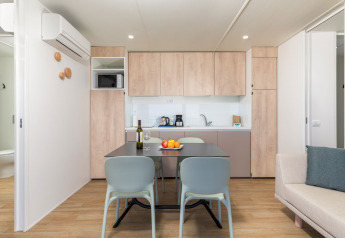 Cucina moderna e zona pranzo al Camping Home di Camping Arena Stupice, Croazia, con arredo in legno chiaro.