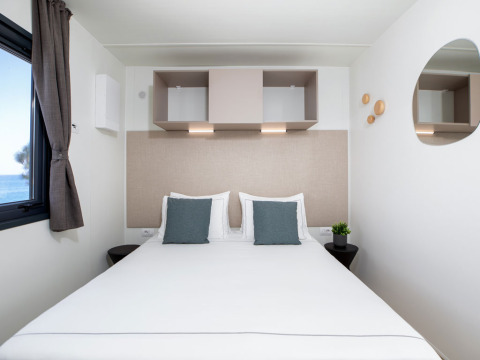Moderne slaapkamer met zeezicht bij Camping Home Sea View op Camping Arena Stupice in Kroatië.