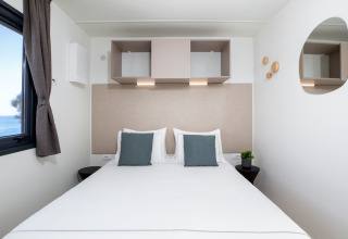 Dormitorio moderno con vista al mar en Camping Home Sea View en Camping Arena Stupice, Croacia.