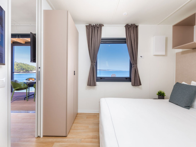 Lichte slaapkamer met zeezicht bij Camping Home Sea View, Camping Arena Stupice, Kroatië.