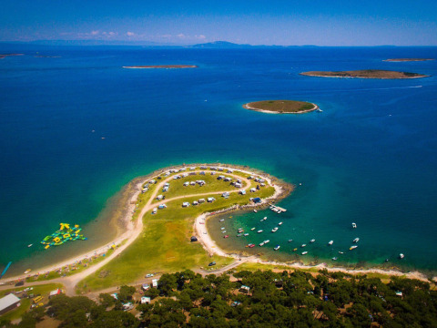 Camping Arena Stupice in Istria, Croatia, aerial view of campers by the blue sea with islands in the distance.