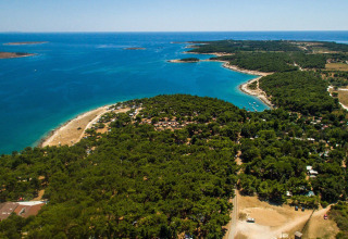 Vista aerea di Camping Arena Stupice in Istria, Croazia, con costa, mare turchese e fitta vegetazione.