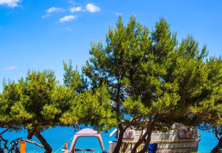 Parque de vacaciones Camping Arena Stupice en Istria, Croacia con caravana, tienda y vistas al mar.