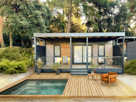 Lodge moderno al Porton Pool nel Camping Porton Nature Hideouts in Croazia con terrazza in legno e piscina.