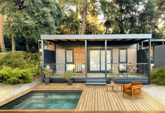 Moderne Lodge am Porton Pool im Camping Porton Nature Hideouts in Kroatien mit Holzdeck und Pool.