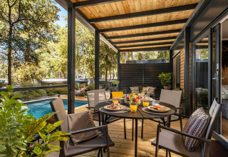 Terrazza all'aperto al Porton Pool Lodge, Camping Porton Nature Hideouts, Croazia, apparecchiata per colazione.