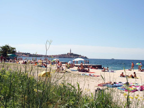 Bagnanti si rilassano sulla spiaggia di Camping Porton Nature Hideouts in Istria, Croazia, vicino al mare.