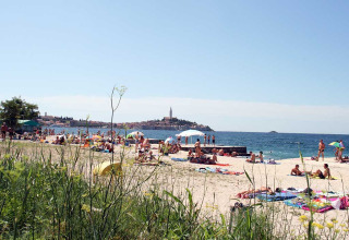 Bagnanti si rilassano sulla spiaggia di Camping Porton Nature Hideouts in Istria, Croazia, vicino al mare.