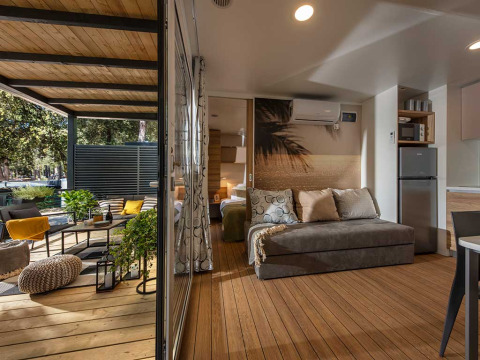 Moderne lodge bij Camping Porton Nature Hideouts in Kroatië met een gezellige veranda en stijlvol interieur.