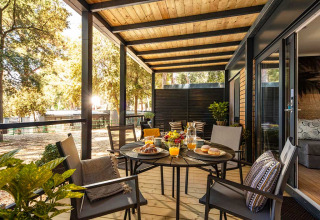 Outdoor terrace at Porton lodge in Campsite Porton Nature Hideouts, Croatia, set for breakfast in the sun.