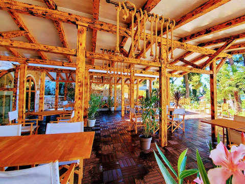 Outdoor dining area with wooden beams, ropes, and plants at Camping Porton Nature Hideouts in Istria, Croatia.
