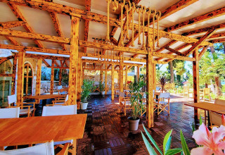 Outdoor dining area with wooden beams, ropes, and plants at Camping Porton Nature Hideouts in Istria, Croatia.