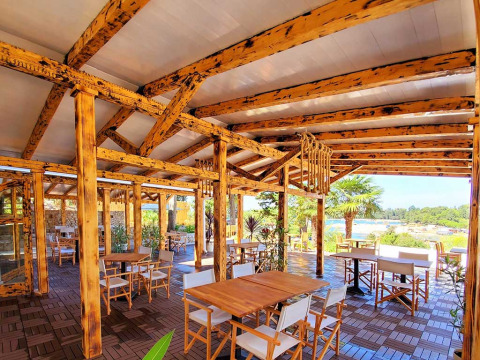 Open-air dining area with wooden beams and seating at Camping Porton Nature Hideouts in Istria, Croatia.