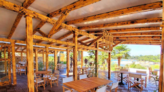 Buitenterras met houten tafels en stoelen bij Camping Porton Nature Hideouts in Istrië, Kroatië.