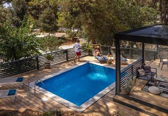 Houten terras met privézwembad en loungestoelen bij Porton Pool, Camping Porton Nature Hideouts, Kroatië.