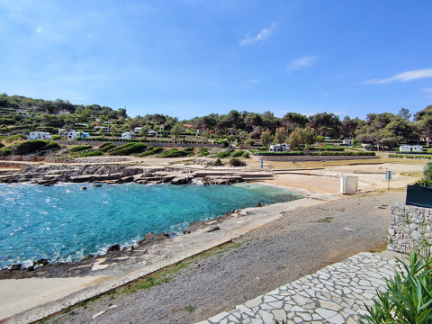 Strand og campingvogne på Baia Holiday Poljana, Primorje-Gorski Kotar, Kroatien, med klart blåt havvand.