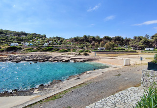 Strand og campingvogne på Baia Holiday Poljana, Primorje-Gorski Kotar, Kroatien, med klart blåt havvand.