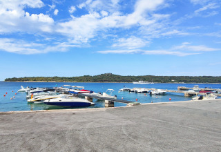 Barche ormeggiate al villaggio Baia Holiday Poljana a Primorje-Gorski Kotar, Croazia, sotto un cielo azzurro.