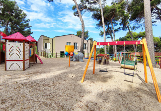 Parque infantil con columpios, tobogán y casita en Baia Holiday Poljana en Primorje-Gorski Kotar, Croacia, al aire libre.