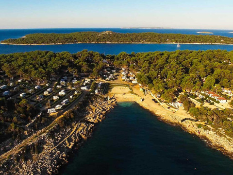 Vista aerea di Baia Holiday Poljana, villaggio turistico con camper, pineta e spiaggia in Croazia.
