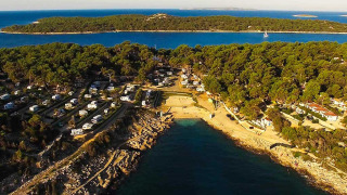 Luchtfoto van Baia Holiday Poljana, een vakantiepark met campers, strand en bos in Kroatië.