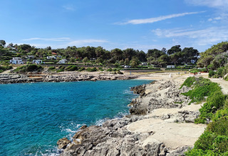 Udsigt over kysten ved Baia Holiday Poljana feriepark i Primorje-Gorski Kotar, Kroatien, med klart blåt vand.