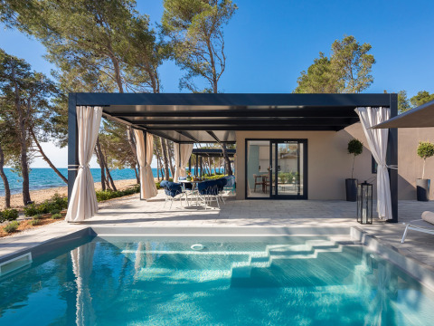 Amber Sea Luxury Holiday Home Pool: Modernes Chalet mit privatem Pool, Terrasse und Meerblick am Strand.